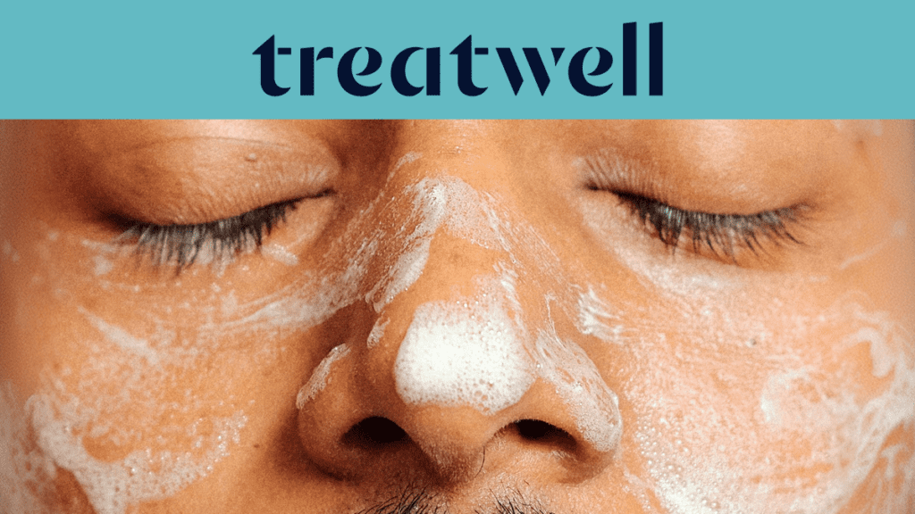 A close-up of a person’s face with their eyes closed during a skincare treatment, with white foaming cleanser applied to the nose and cheeks. A teal banner at the top features the Treatwell logo.